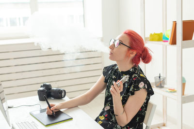 Young woman photographing on table