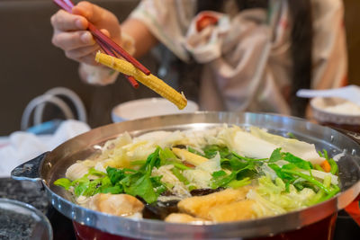 Close-up of person preparing food in plate