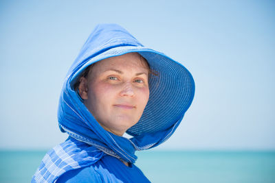 Portrait of woman against blue sea against sky