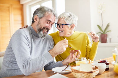 Smiling couple having breakfast at home