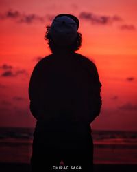 Rear view of silhouette man standing against sky during sunset