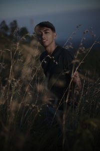 Young man looking away on field