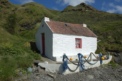 House by mountains against sky