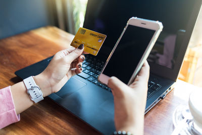 Midsection of man using mobile phone on table