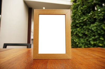 Close-up of blank picture frame on wooden table