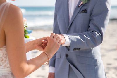 Midsection of couple exchanging wedding ring
