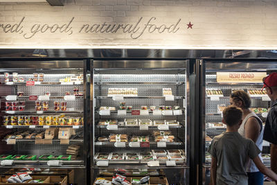 Rear view of people standing at store