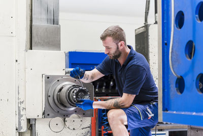 Man working on machine in industrial factory