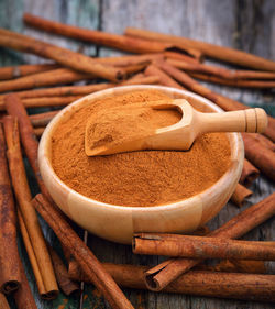 Close-up of cinnamons with grounded spice on table