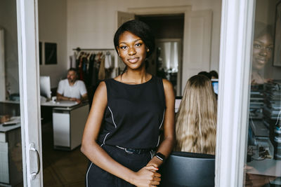 Smiling female entrepreneur standing by colleague in office