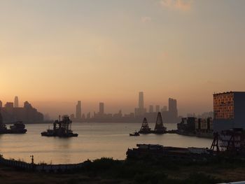 Scenic view of sea and buildings against sky during sunset