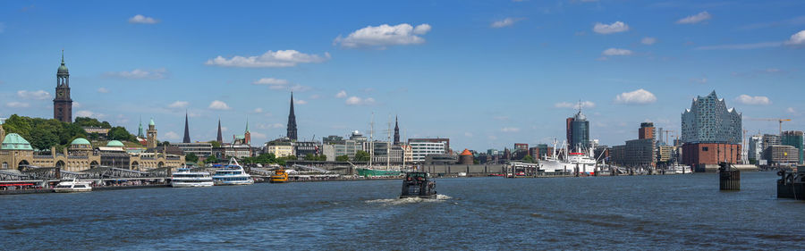 Boats in city against sky