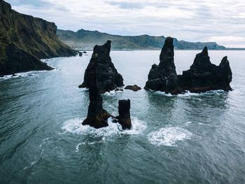 Rock formation in sea against sky