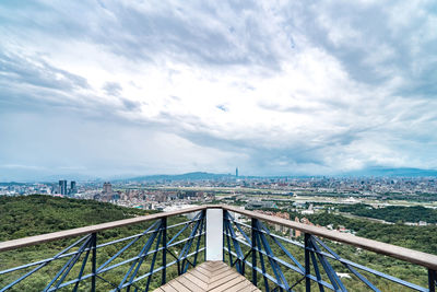 Bridge over river in city against sky