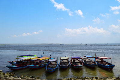 Boats moored in sea against sky