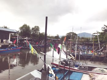 Panoramic view of people by river in city against sky