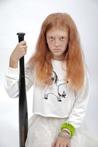 Portrait of a girl standing against white wall