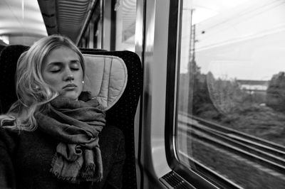 Young woman sleeping while traveling in train