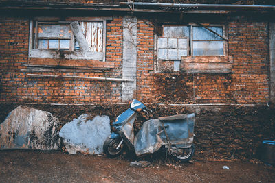 Abandoned scooter and building in city