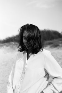 Rear view of woman on beach against sky