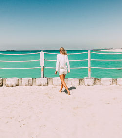 Full length of man standing on beach against clear sky