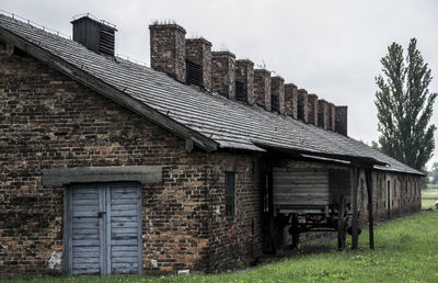 Exterior of abandoned house on field against sky