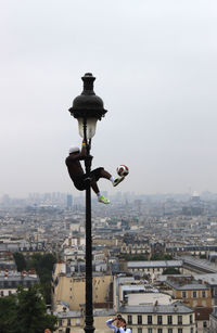 Man hanging on street light