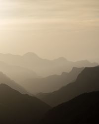 Scenic view of silhouette mountains against sky during sunset