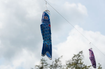 Low angle view of fish hanging against sky