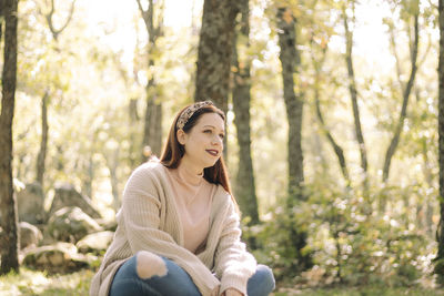Young woman sitting on a picnic table surrounded by a forest