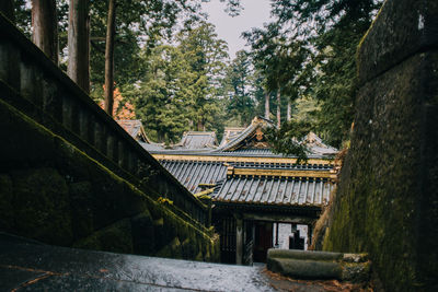 Houses amidst trees and buildings against sky