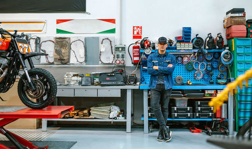 Mechanic man standing in front of workbench in motorbike workshop