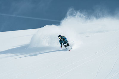 People skiing on snow covered landscape