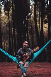 Full length of man playing in forest