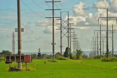 Electricity pylon on field against sky