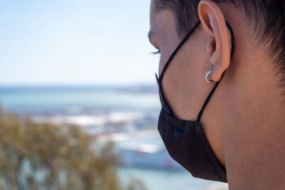 Close view of man using face mask with malaga city on the background.