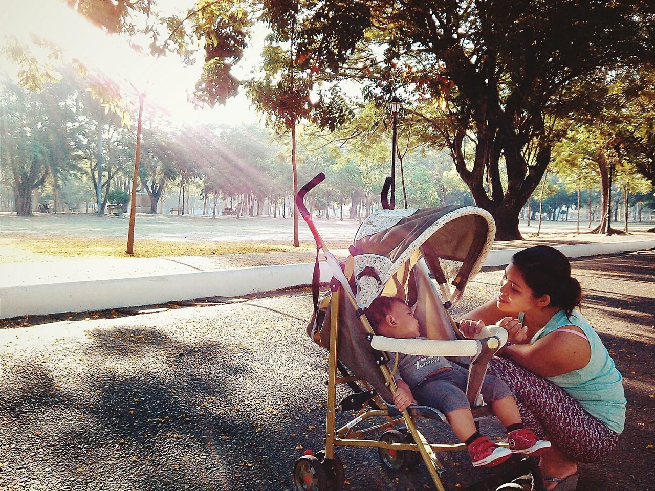 tree, childhood, person, lifestyles, leisure activity, sunlight, playground, casual clothing, elementary age, swing, girls, boys, park - man made space, full length, sitting, day, transportation, incidental people