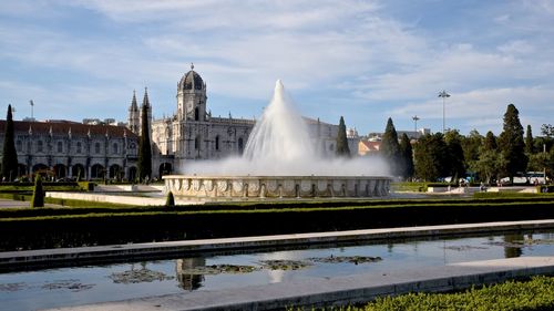 Fountain and mosteiro dos jeronimos against cloudy sky