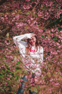 Portrait of woman standing by tree