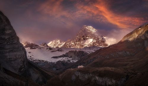 Scenic view of snowcapped mountains against sky during sunset