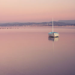 Sailboat in sea against sky during sunset