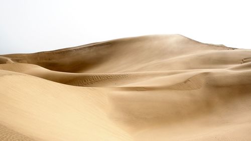 Sand dunes in desert against sky