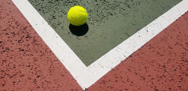 High angle view of yellow tennis ball on court