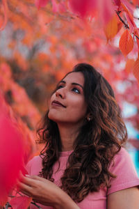 Young woman touching autumn leaves