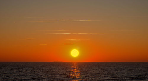 Scenic view of sea against orange sky