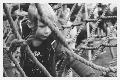 Boy playing amidst rope at playground