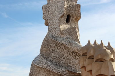 Low angle view of statues on building against sky