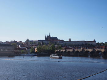 Bridge over river against buildings in city