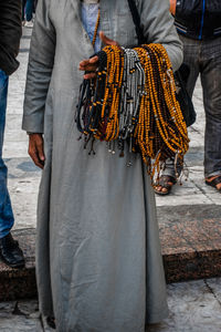 Low section of man selling religious beads necklace while standing in market