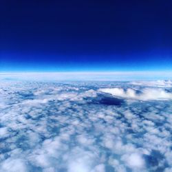 Aerial view of cloudscape against clear blue sky